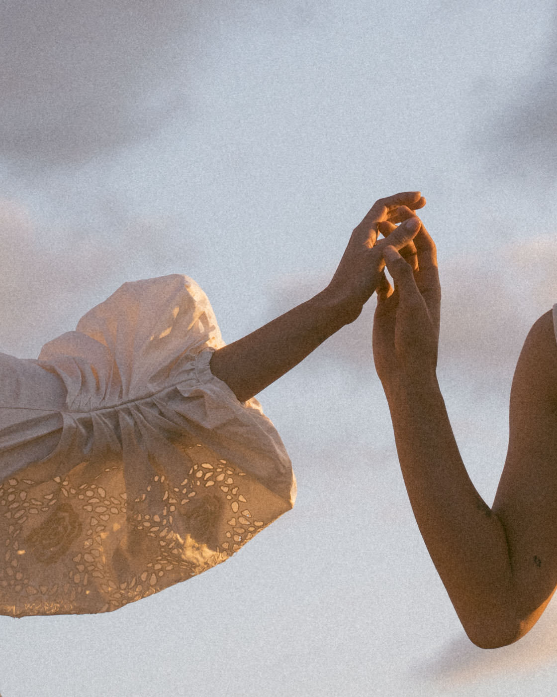 Wedding couple intimately touching hands at sunset in Spain, capturing a tender moment of connection