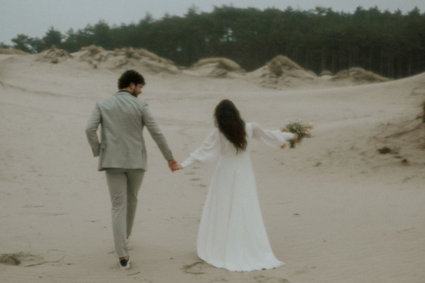 Timeless wedding couple at the beach, holding each other in a serene embrace.