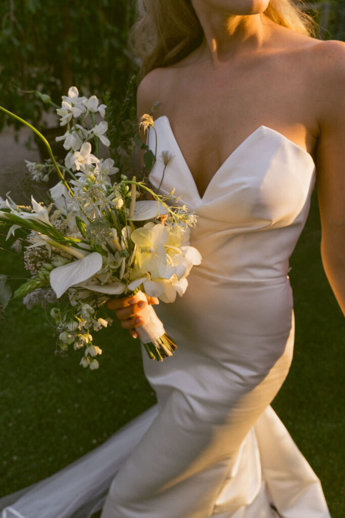 bride waring a classy dress and holds a beautiful bouquet