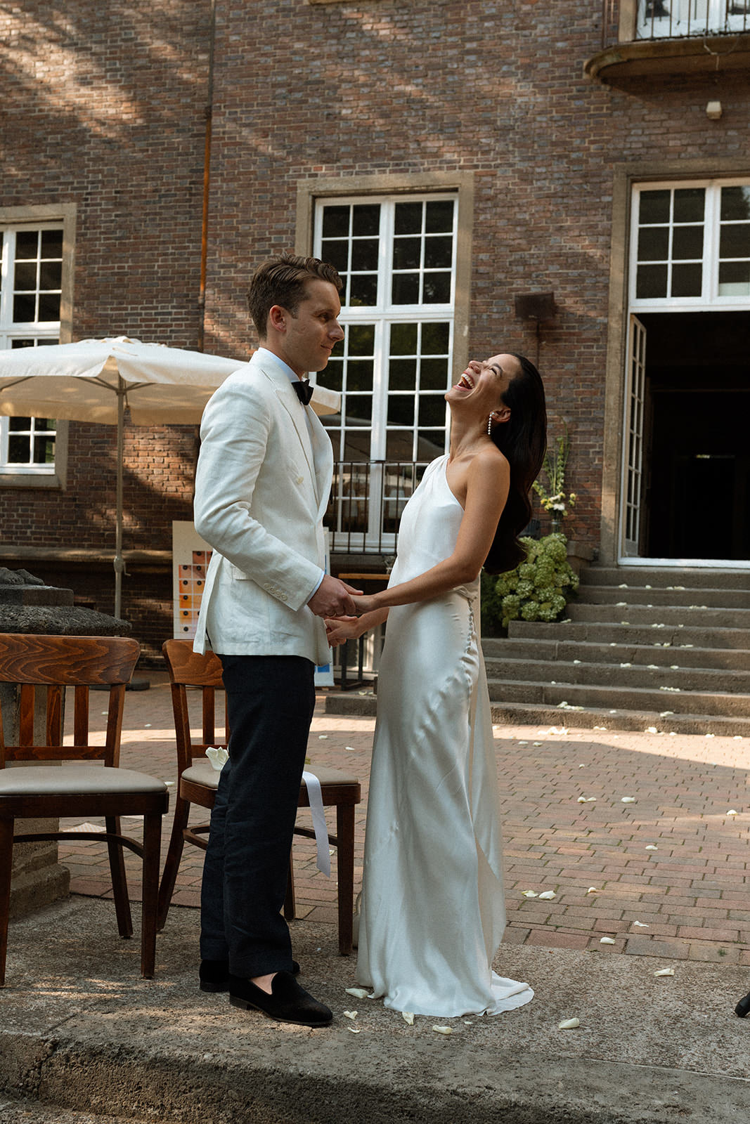 The bride and groom sharing a joyful moment in the courtyard of Villa Mignon.