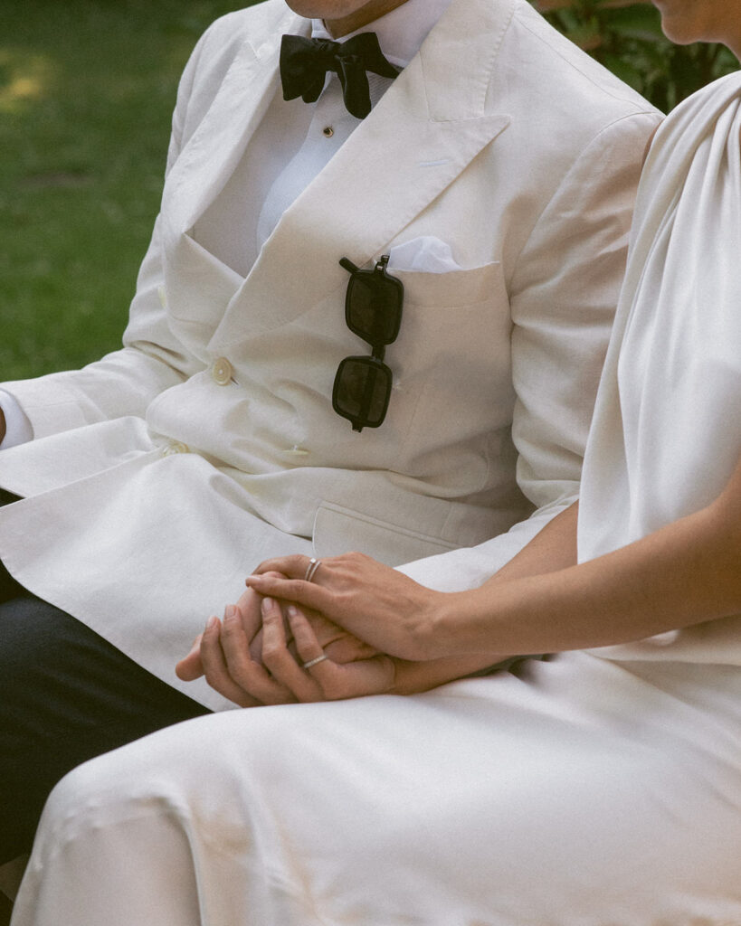 A close-up shot of a bride and groom holding hands during their Tuscany wedding, captured by a film photographer.