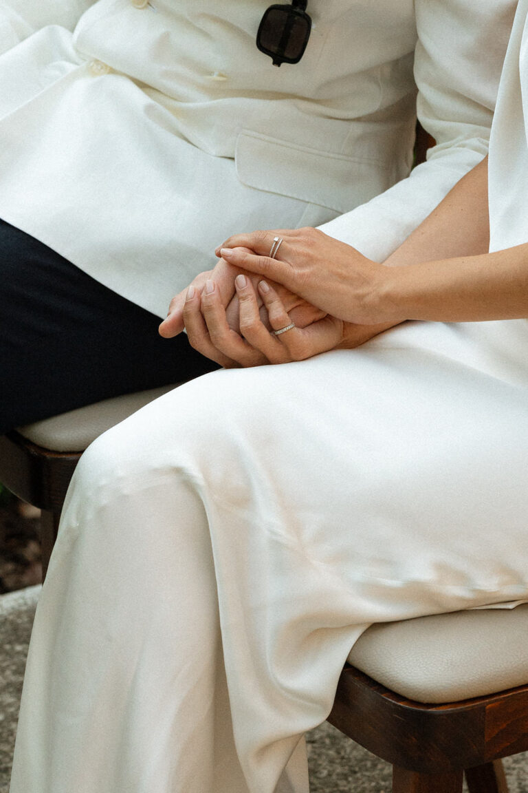 A close-up of the bride and groom holding hands during their wedding ceremony at Villa Mignon.